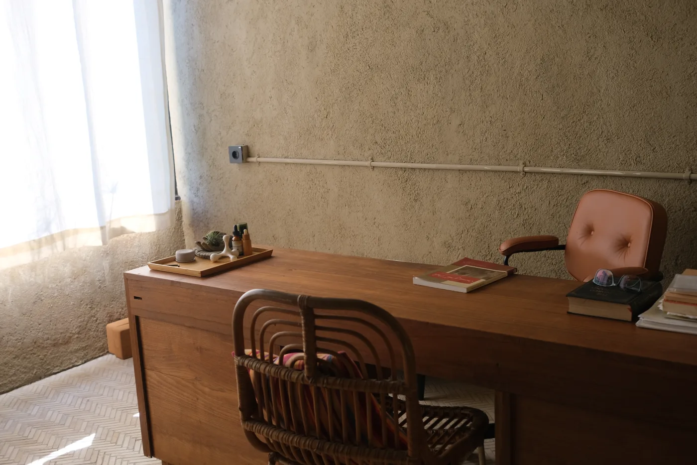 Soft light across the Vedic Counseling room desk, chair, and reading materials